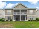 The back of this two-story townhome offers a serene view of its green lawn and screened in porch at 964 Great Egret Circle Sw # B, Sunset Beach, NC 28468