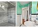 Bathroom boasts tiled shower with glass door, classic black and white tile detail and seafoam green walls at 1008 N Withlacoochee Ave., Marion, SC 29571