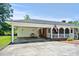 Exterior with covered parking and charming porch with classic American flag, blending function with patriotism at 1008 N Withlacoochee Ave., Marion, SC 29571