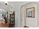Hallway with hardwood floors, decorative glass front door reflected in mirror, and charming vintage display cabinet at 1008 N Withlacoochee Ave., Marion, SC 29571