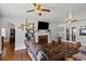 Cozy living room featuring a brick fireplace, hardwood floors, and two ceiling fans for ultimate comfort and style at 1008 N Withlacoochee Ave., Marion, SC 29571
