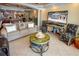 Bright living room featuring a tan sofa, elegant decor, and a TV showcasing a beachfront view at 1012 N Waccamaw Dr. # 305, Garden City Beach, SC 29576