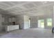 Spacious living room featuring an open layout, unfinished flooring, and natural light streaming through large windows at 1014 Black Locust Pl., Longs, SC 29568