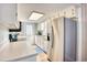 Well-lit kitchen features a stainless steel fridge, white cabinetry, and laminate countertops at 121 Easy St., Garden City Beach, SC 29576