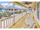 Relaxing porch with white rocking chairs and a view of neighboring stilted houses at 121 Easy St., Garden City Beach, SC 29576
