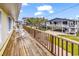 Wooden porch with rocking chairs overlooking a lush green lawn and other elevated beach houses at 121 Easy St., Garden City Beach, SC 29576