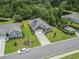 Aerial view of a home with solar panels, a manicured lawn, and a paved driveway in a tranquil neighborhood at 124 Castaway Key Dr., Pawleys Island, SC 29585