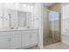 Bathroom features double sink vanity, a framed mirror, and a glass shower with neutral tile at 124 Castaway Key Dr., Pawleys Island, SC 29585