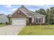 Charming home exterior featuring a stone facade, gray siding, red shutters and manicured front yard at 124 Castaway Key Dr., Pawleys Island, SC 29585