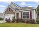 Charming home exterior with stone accents, gray siding, red shutters, and well-manicured landscaping at 124 Castaway Key Dr., Pawleys Island, SC 29585