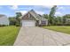 Well-maintained home exterior featuring stone accents, a two-car garage, and a long driveway with landscaping at 124 Castaway Key Dr., Pawleys Island, SC 29585