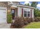 Inviting front entrance with a red door, stone accents, manicured bushes and a well-kept lawn at 124 Castaway Key Dr., Pawleys Island, SC 29585