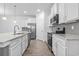 Modern kitchen features stainless appliances, granite countertops, gray backsplash, and white cabinets at 124 Castaway Key Dr., Pawleys Island, SC 29585