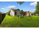 Well-maintained backyard with lush green grass, a fence, and a charming wooden swing set and play area at 124 Shady Arbor Loop, Longs, SC 29568