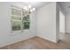 Bright dining area features wood-look floors, a modern chandelier, and a large window with natural light at 124 Shady Arbor Loop, Longs, SC 29568