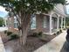 Exterior view of a brick building with meticulously maintained landscaping and a covered walkway with columns at 124 Shady Arbor Loop, Longs, SC 29568