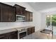 Modern kitchen boasts stainless steel appliances, dark cabinets, a center island, and granite countertops at 124 Shady Arbor Loop, Longs, SC 29568