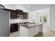 Modern kitchen boasts stainless steel appliances, dark cabinets, a center island, and a bright window at 124 Shady Arbor Loop, Longs, SC 29568
