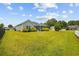 Large, lush backyard featuring mature landscaping and a charming view of the home's exterior at 1304 Marley St., Conway, SC 29527
