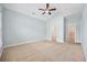 Spacious bedroom with a fan, and neutral carpet leading to ensuite bathroom and closet at 1304 Marley St., Conway, SC 29527