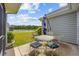 Cozy outdoor patio with table, chairs, and an umbrella overlooking lush green grass and lake views at 1304 Marley St., Conway, SC 29527