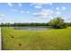 Peaceful pond view with lush green lawn extending to the water's edge, partially fenced for safety at 1304 Marley St., Conway, SC 29527