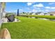 Spacious backyard with lush green grass, pond view, and patio area with grill at 136 Crabapple Dr., Longs, SC 29568