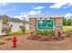 Welcoming Oak Hollow community sign featuring a stone base and lush floral arrangements at 136 Crabapple Dr., Longs, SC 29568