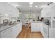 Bright eat-in kitchen features white cabinets, stainless appliances, and hardwood floors at 1478 Bluegil Dr., Longs, SC 29568