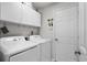 Bright laundry room with white washer and dryer set and storage cabinets at 1478 Bluegil Dr., Longs, SC 29568