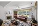 Cozy living room with hardwood floors, fireplace, and large windows providing plenty of natural light at 1478 Bluegil Dr., Longs, SC 29568