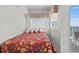 Cozy bedroom featuring bright window, floral bedding and access to the outdoor balcony at 1605 S Ocean Blvd. # 1403, Myrtle Beach, SC 29577