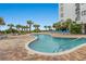 Exterior view of a community pool with palm trees and plenty of lounge chairs at 1605 S Ocean Blvd. # 1403, Myrtle Beach, SC 29577