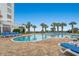 Resort-style pool surrounded by palm trees and lounge chairs with partial ocean views at 1605 S Ocean Blvd. # 1403, Myrtle Beach, SC 29577