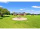 Large backyard featuring a brick firepit area, expansive green lawn, and mature trees at 1752 Patriot Ct., Mullins, SC 29574