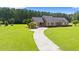 Expansive front lawn featuring the charming brick home with well-manicured landscaping and a long driveway at 1752 Patriot Ct., Mullins, SC 29574