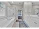Bright bathroom featuring a bathtub, separate shower, and double vanity with white cabinetry and a view to the bedroom at 179 Cottage Ct., Pawleys Island, SC 29585