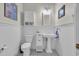 Charming powder room with wainscoting, a pedestal sink, a toilet, and decorative storage for a classic design at 179 Cottage Ct., Pawleys Island, SC 29585