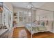 Light-filled bedroom showcasing a four-poster bed, plantation shutters, and wood floors for a warm and inviting atmosphere at 179 Cottage Ct., Pawleys Island, SC 29585