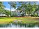 Exterior of a home overlooking a pond showcasing its well-maintained lawn and waterside setting, with the home partially obscured at 179 Cottage Ct., Pawleys Island, SC 29585