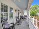 Comfortable front porch with a porch swing, chairs, and a clear view of the neighborhood from the home's large windows at 179 Cottage Ct., Pawleys Island, SC 29585