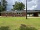 Back view of brick home featuring a carport and large yard at 189 Lewis Rd., Hemingway, SC 29554