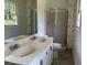 Bathroom with a double sink vanity, mirrored wall, enclosed shower, built-in cabinets and a window view at 189 Lewis Rd., Hemingway, SC 29554