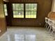 The sun room has panelled walls and a pair of windows looking out to the greenery of the property at 189 Lewis Rd., Hemingway, SC 29554