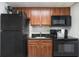 A cozy kitchen featuring dark appliances, wood cabinets, and a granite countertop at 2000 N Ocean Blvd. # 1810, Myrtle Beach, SC 29577