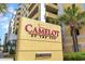 Prominent property sign displaying 'Camelot by the Sea' with lush tropical landscaping at 2000 N Ocean Blvd. # 1810, Myrtle Beach, SC 29577