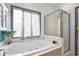 Modern bathroom features a luxurious tub, a clear glass shower, and a sunny window at 203 Old Hickory Dr., Conway, SC 29526