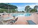 Large community pool surrounded by lounge chairs, umbrellas, and lush greenery for relaxation and recreation at 203 Old Hickory Dr., Conway, SC 29526