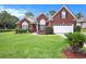 Charming red brick home with manicured lawn, shrubs, and a two-car garage, complete with a well-maintained landscape at 203 Old Hickory Dr., Conway, SC 29526