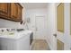 Functional laundry room with modern washer and dryer, overhead cabinets, and neutral tile flooring at 203 Old Hickory Dr., Conway, SC 29526